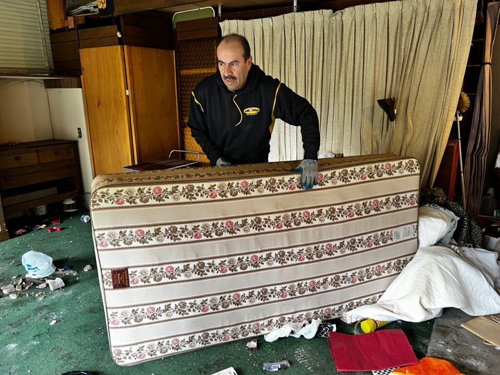 Junk B Gone crew member loading a mattress for removal in Seattle