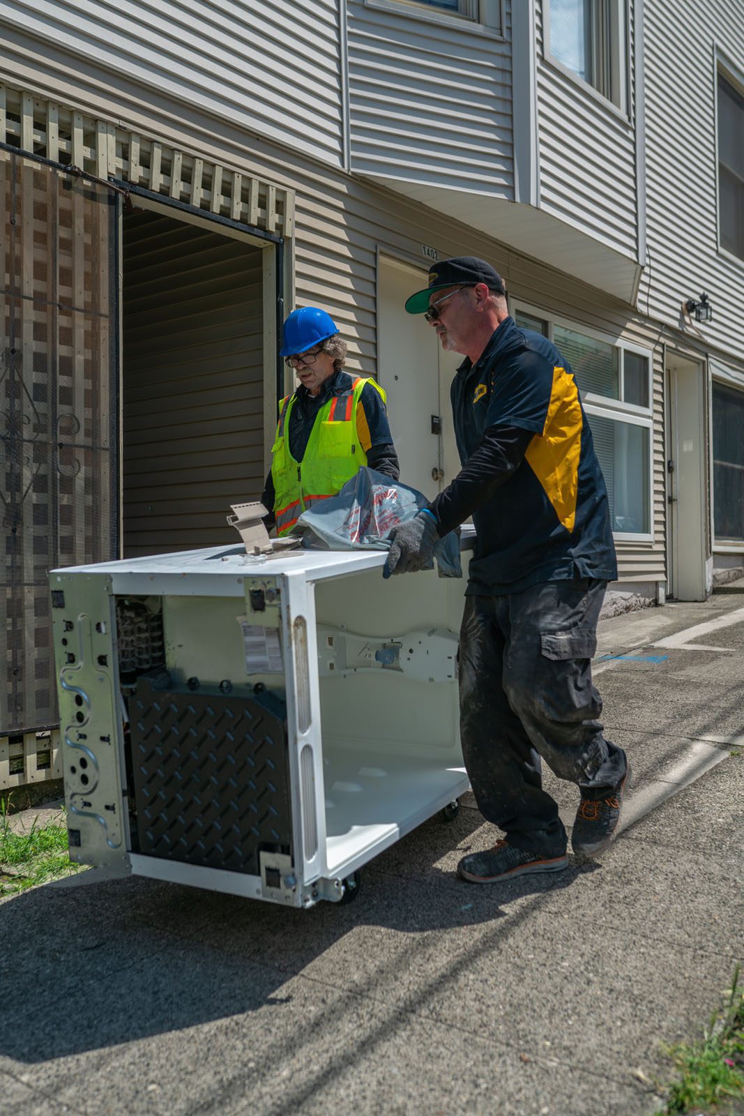 Junk B Gone team hauling old appliances to truck in Seattle