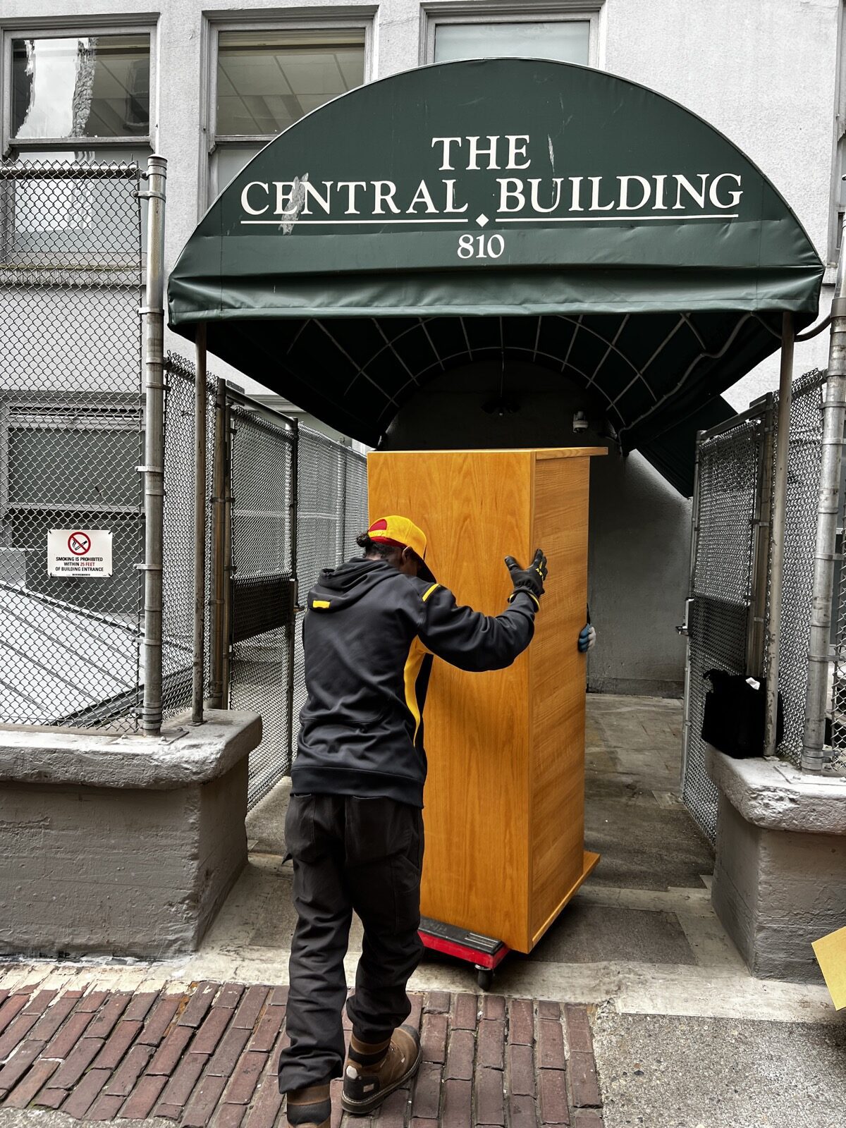 Junk B Gone crew member wheeling a desk out of The Central Building in downtown Seattle