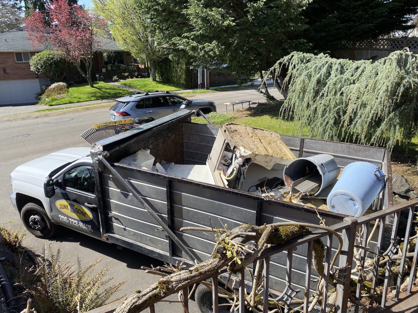 Hot tub, water heater, metal railing, and branches loaded in a Junk B Gone truck