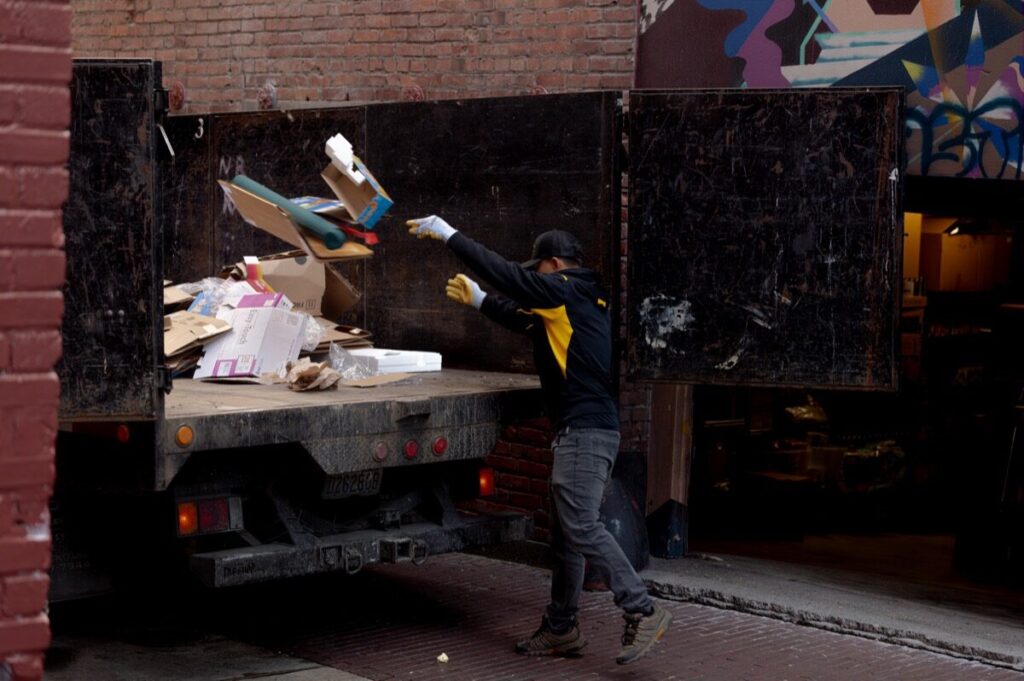 Junk B Gone crew loading cardboard recycling onto truck — Seattle commercial junk removal
