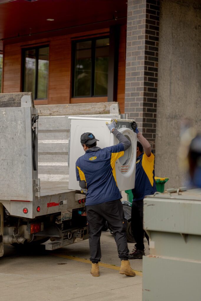 Junk B Gone crew loading dryer onto truck — same-day appliance removal Seattle