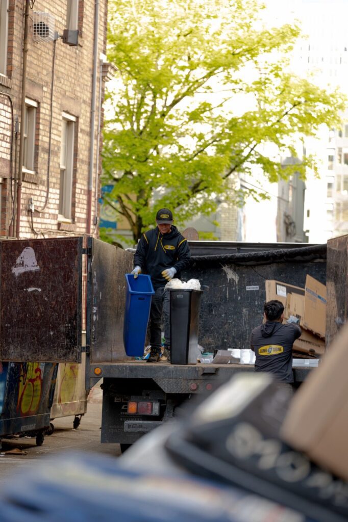 Junk B Gone crew loading recycling totes in downtown Seattle alley — apartment cleanout service