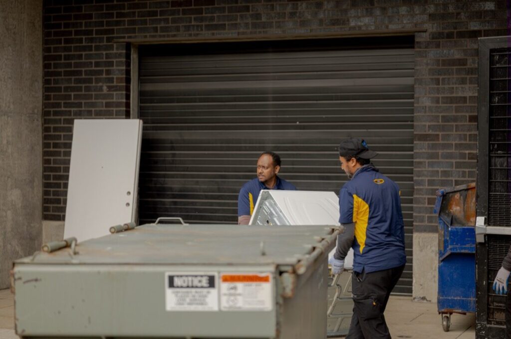 Junk B Gone crew loading washing machine at building loading dock — Seattle appliance removal