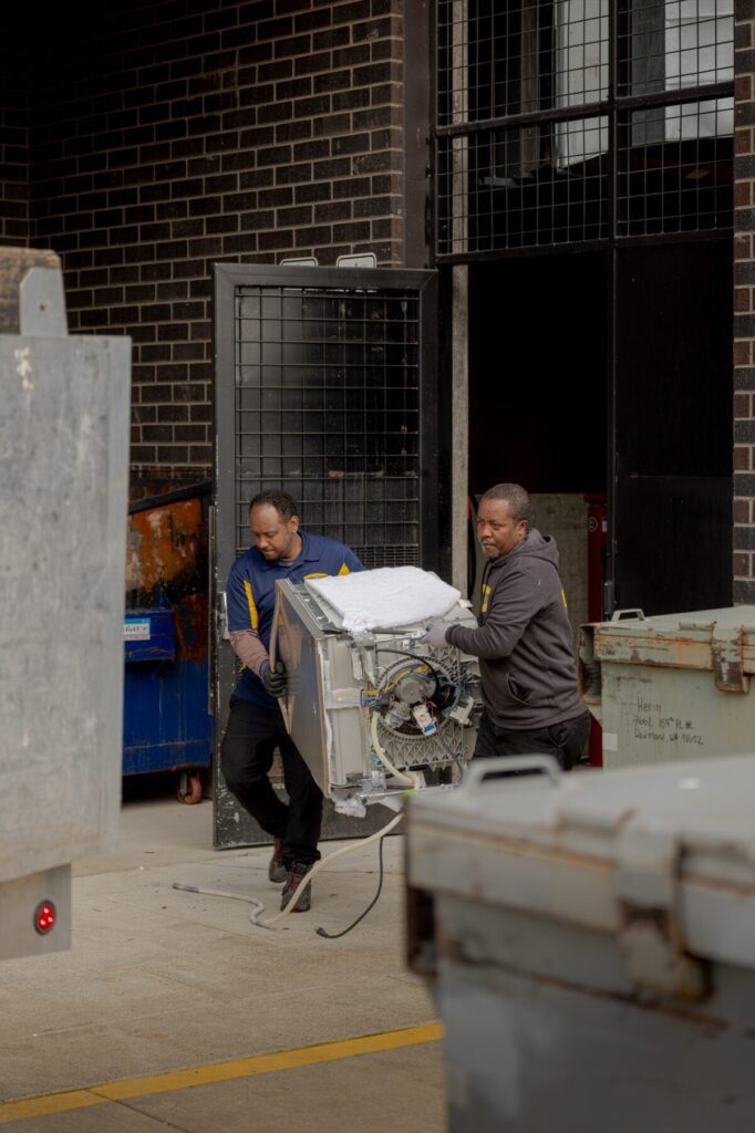 Junk B Gone crew removing dishwasher from building — Seattle commercial appliance removal