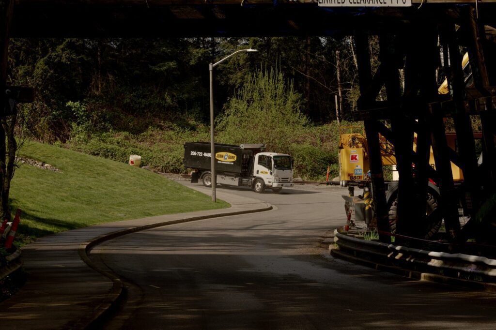 Junk B Gone truck on a wooded Kirkland road — Kirkland junk removal
