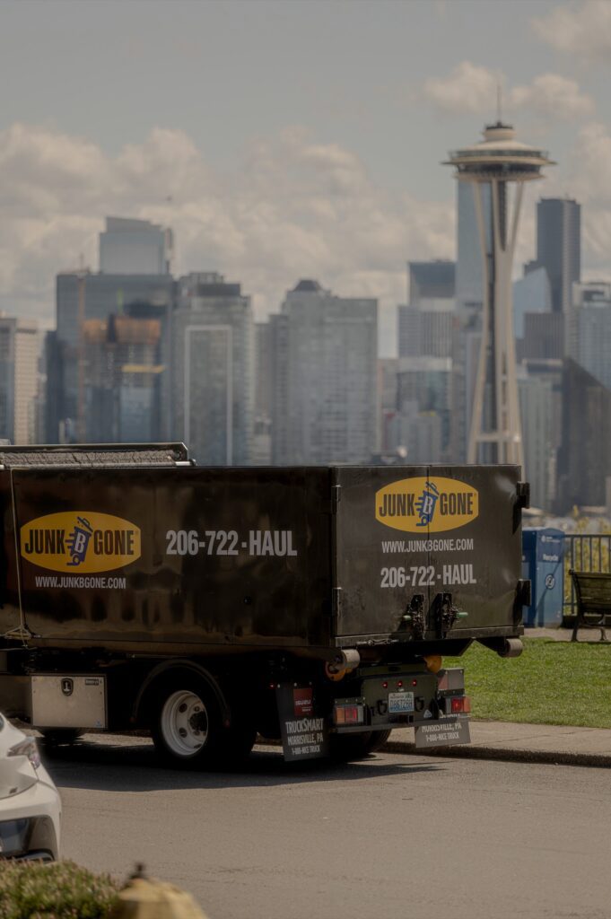 Junk B Gone truck with the Seattle Space Needle and downtown skyline — Seattle's #1 rated junk removal