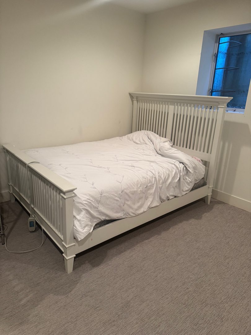 A neatly made bed in a cleared, airy Seattle bedroom left easy to be in