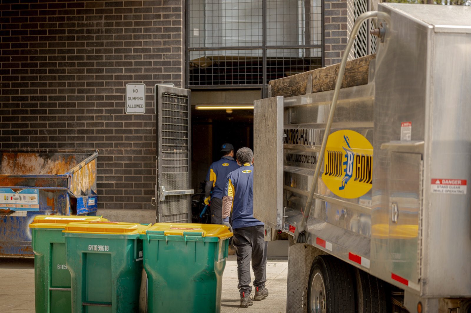 Property cleanout in Seattle - Junk B Gone crew loading at a loading dock with the branded truck staged alongside