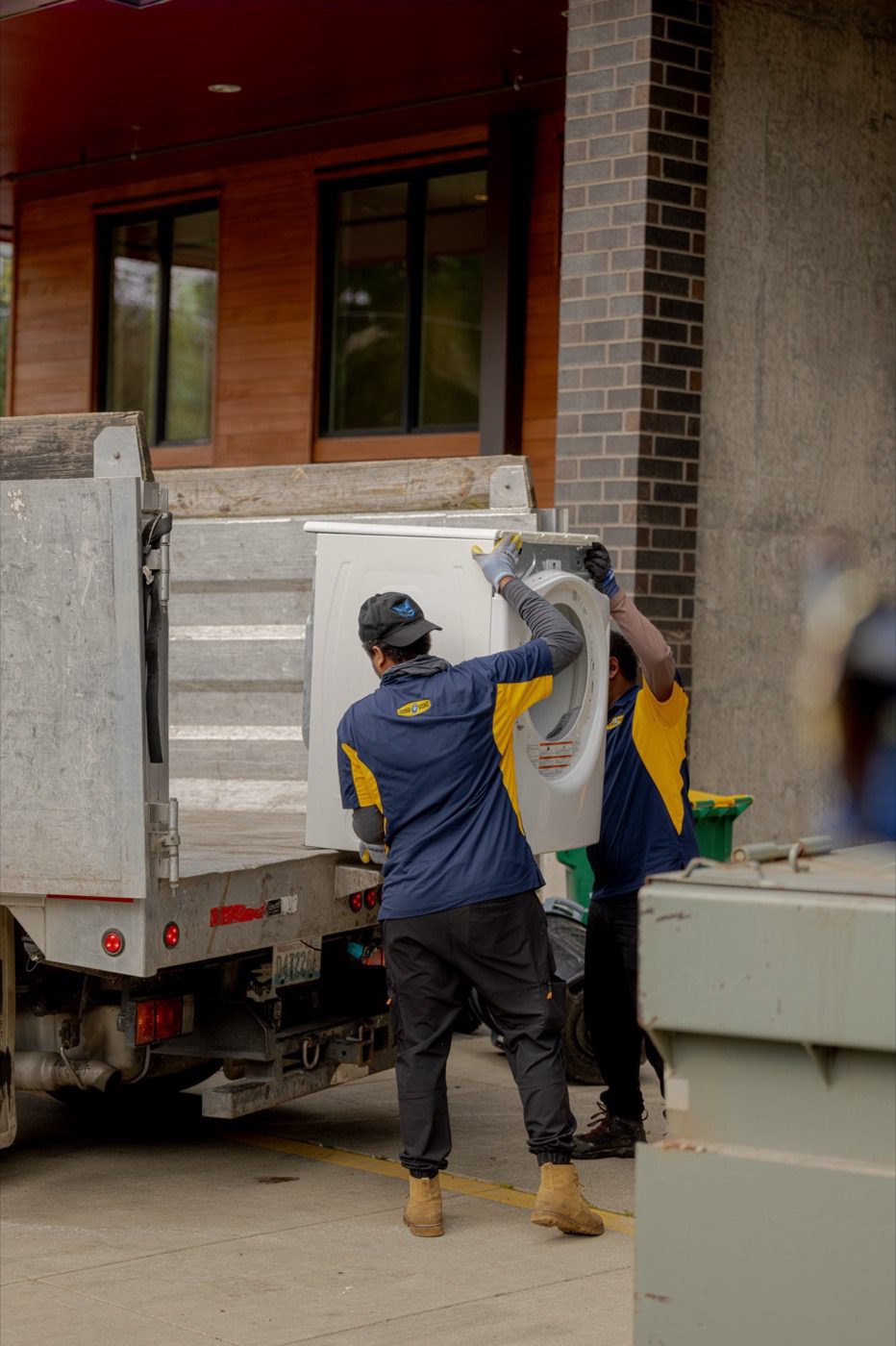 Appliance removal in Seattle - two Junk B Gone crew members loading a washer onto the truck