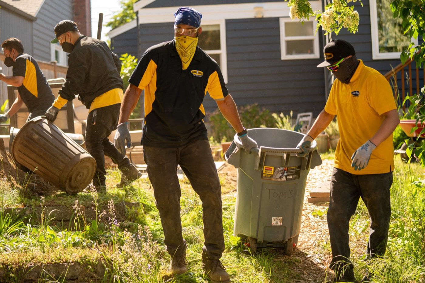 Yard cleanout in Seattle - Junk B Gone crew clearing and loading yard waste from a back lot