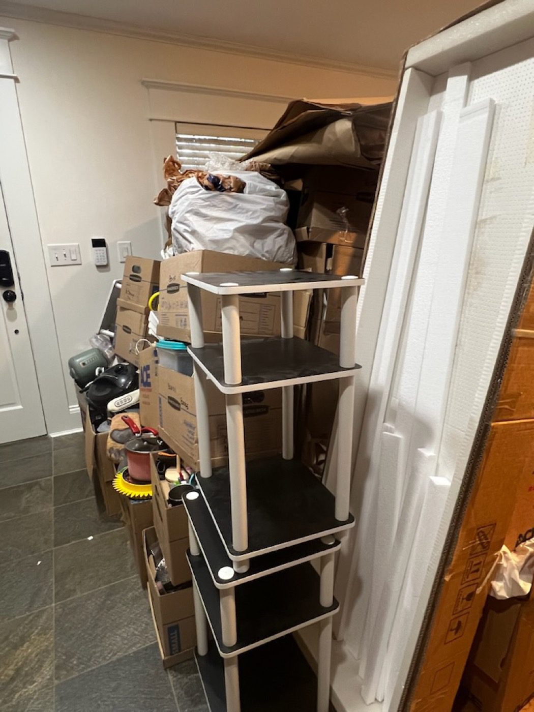 A walk-in storage closet packed with boxes and bins before a Junk B Gone clear-out in Seattle