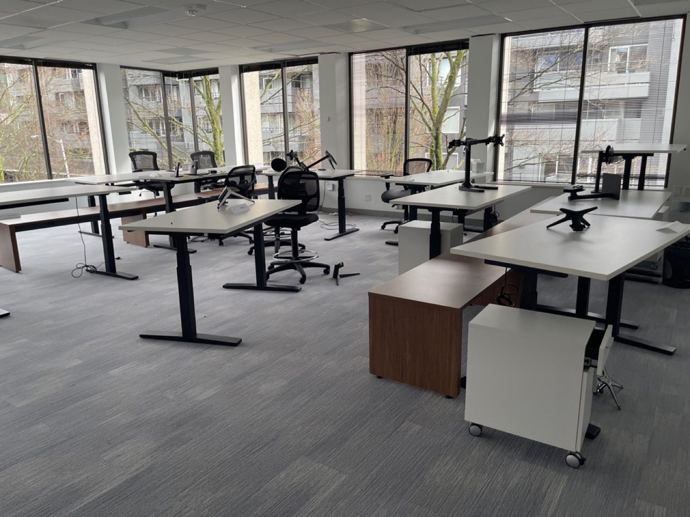Seattle open office full of cabled sit-stand desks before Junk B Gone furniture removal