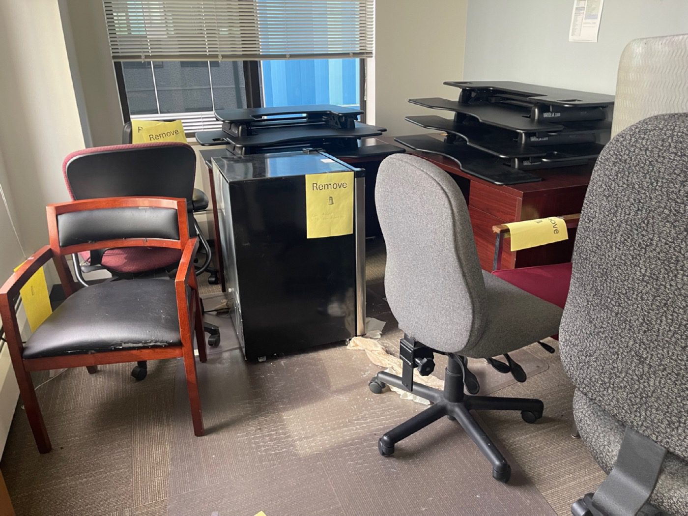 Office furniture removal in Seattle - Junk B Gone crew clearing tagged office chairs, mini-fridge and risers