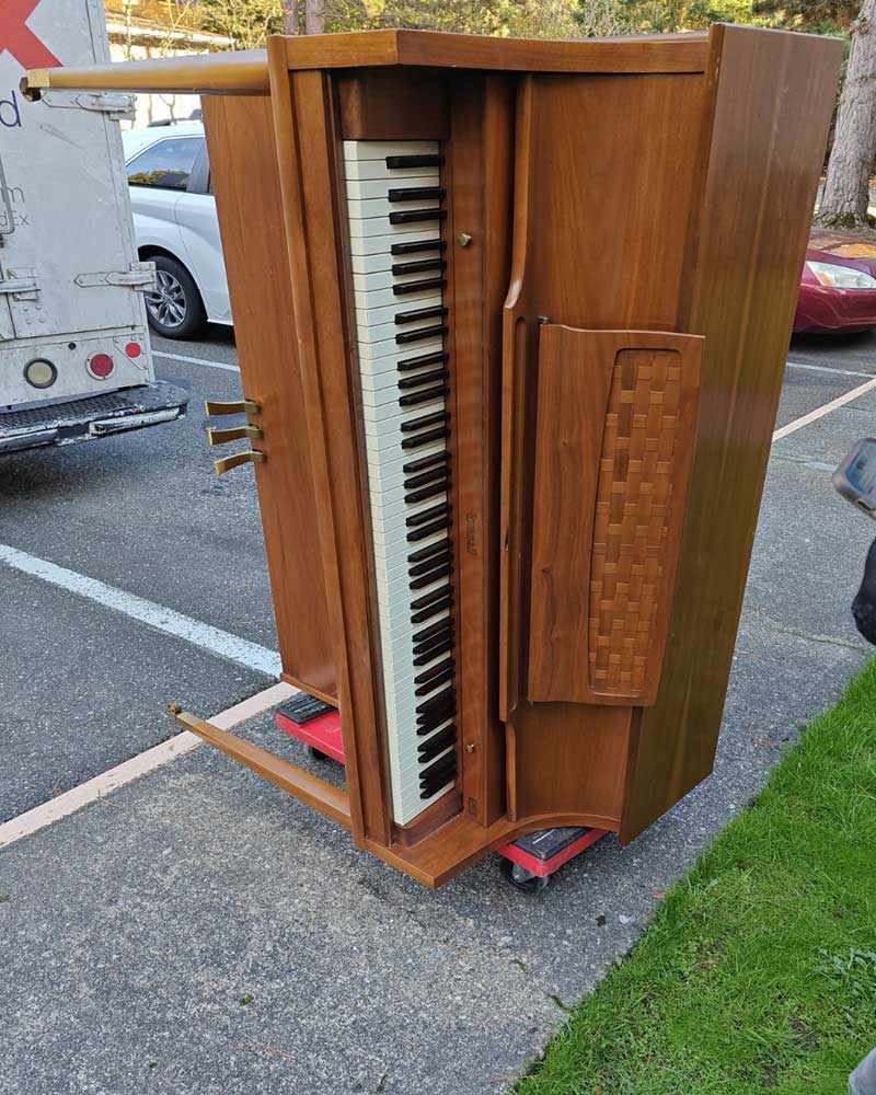 Old upright piano being removed from a home
