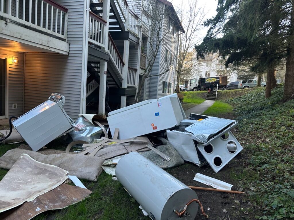Fridges stove water heater and debris piled outside building