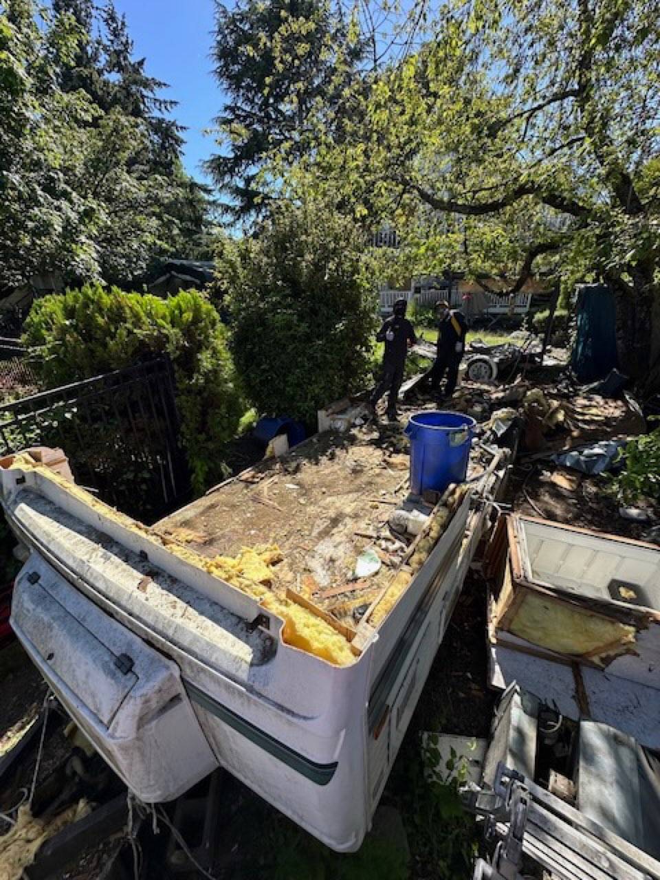 Pop-up trailer bed exposed with debris staged for the truck